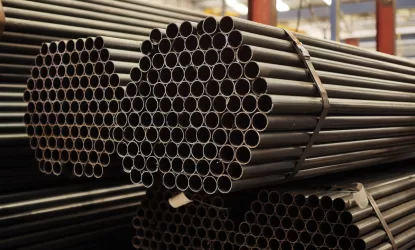 Tubos de aço redondos organizados em feixes industriais, representando diferentes tipos de tubos de aço usados em estruturas metálicas.